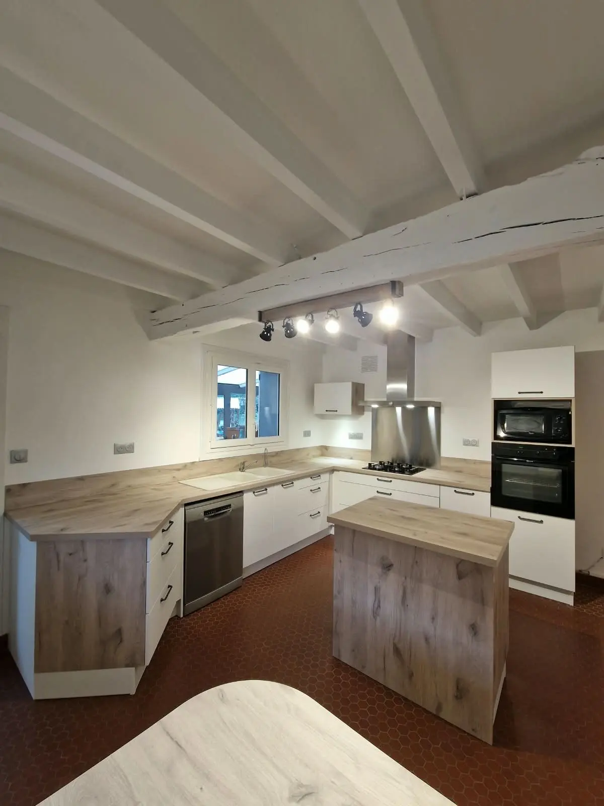 Cuisine d'angle avec îlot, sous plafond à poutres