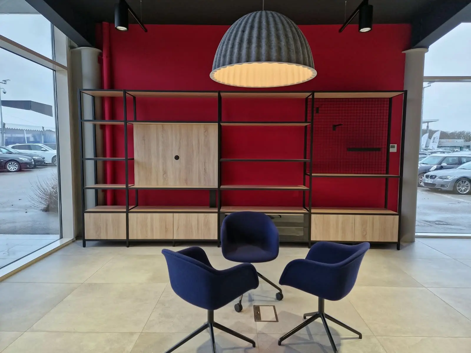 Espace d'accueil, bibliothèque murale sur fond rouge