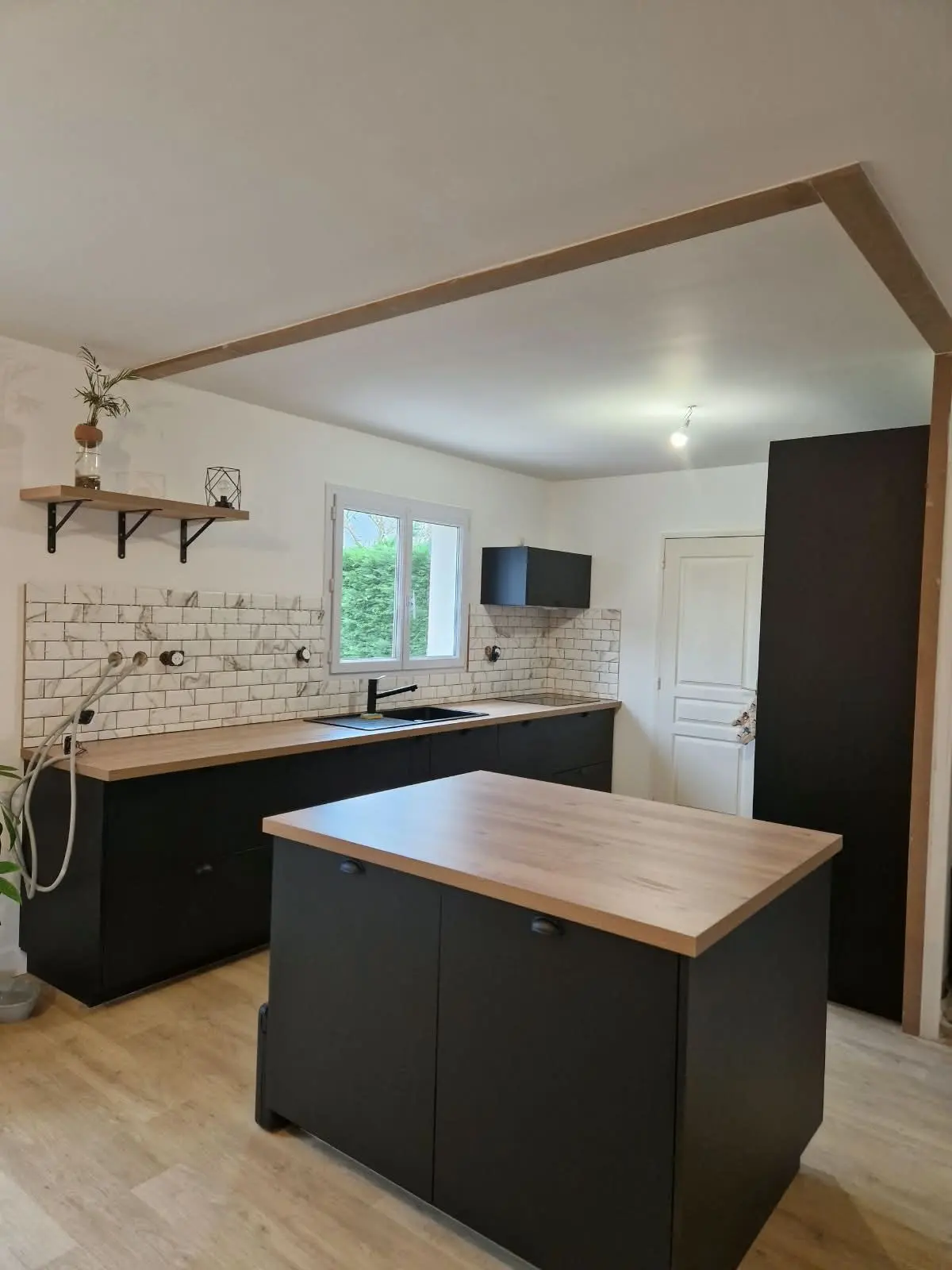 Cuisine noire, îlot et cadre en bois