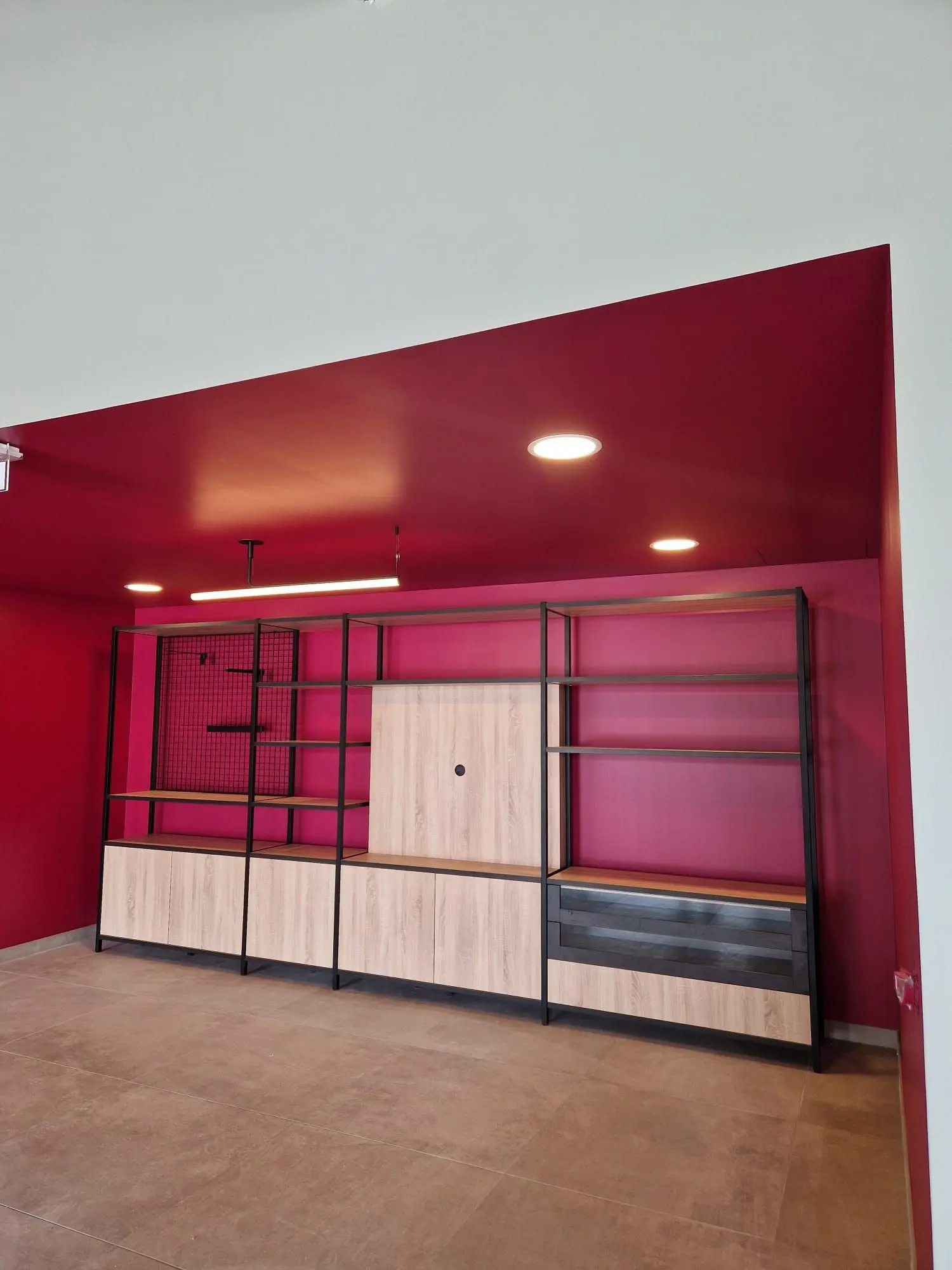 Mur de rangement métal et bois sur fond framboise